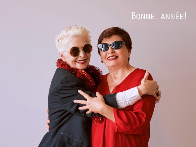 Two beautiful stylish mature senior women celebrating new year Fun party style celebration conce