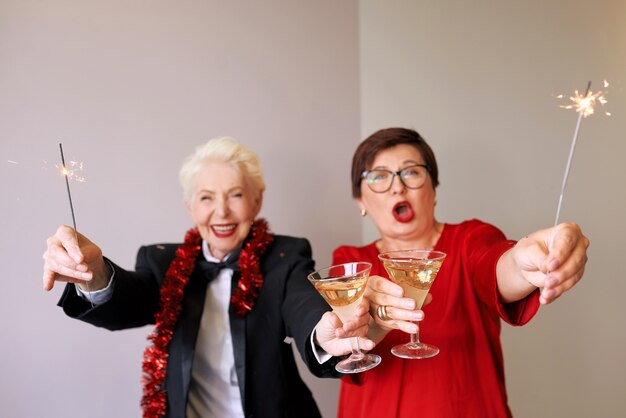 Two beautiful stylish mature senior women celebrating new year