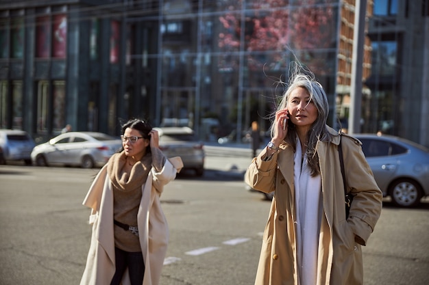 Two beautiful stylish women walking on the street