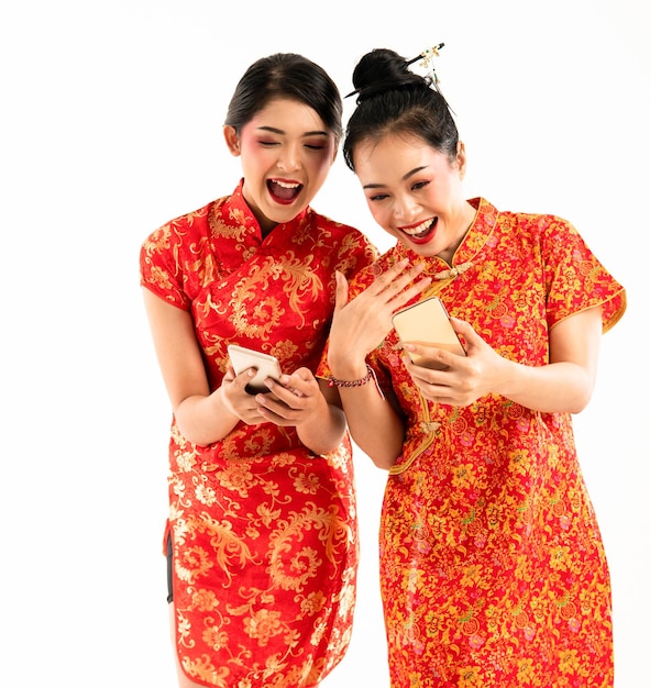 Two beautiful woman in cheongsam standing together look at their phone