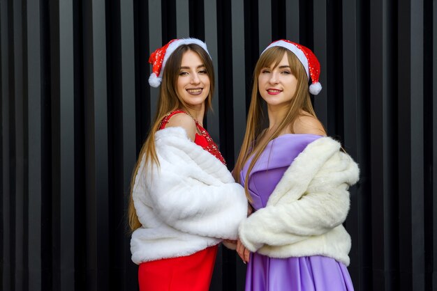 Two beautiful women in elegant dresses celebrating new year