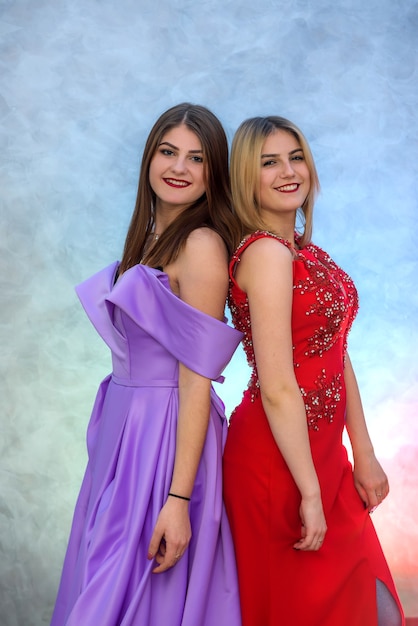 Two beautiful women in elegant dresses celebrating new year