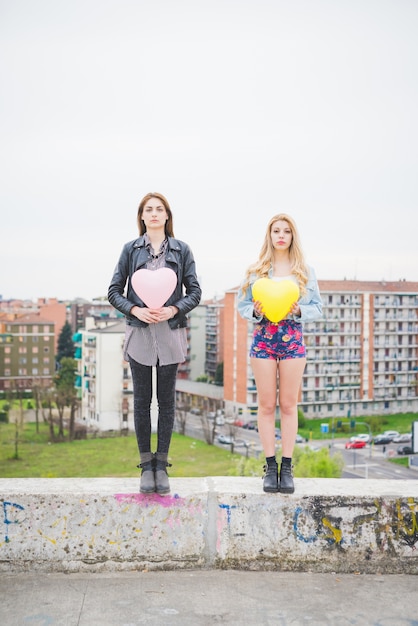 two beautiful women friends playing balloon