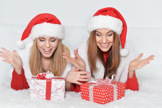 Two beautiful women opening Christmas presents