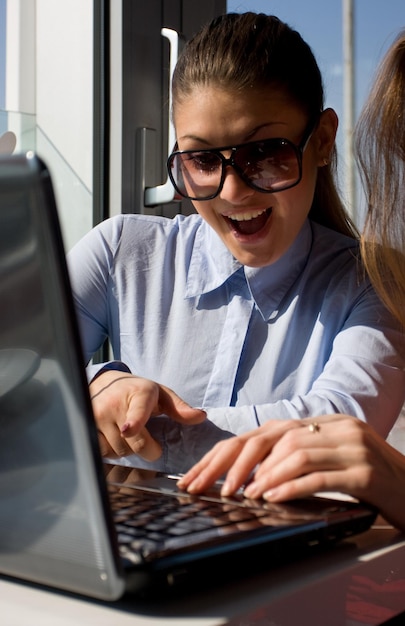 Two beautiful women sitting in cafe with laptop