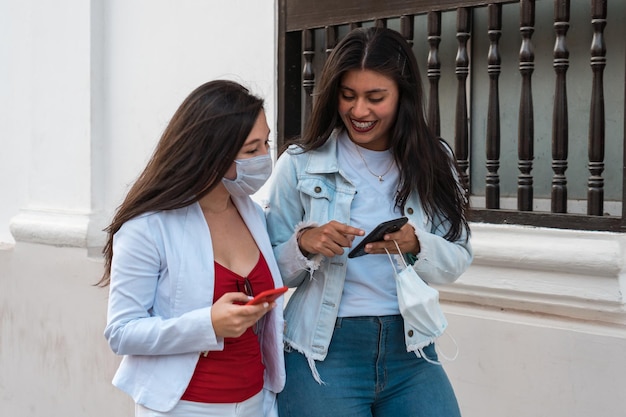 Two beautiful women with protective masks walking in the street