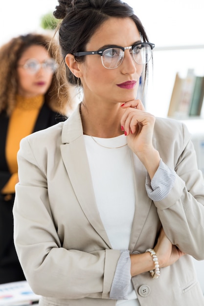 Two beautiful young businesswoman posing in the office.