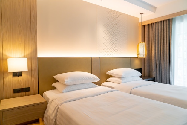 Two beds with pillows in hotel resort bedroom