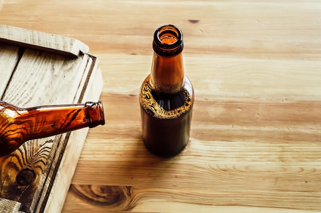 Two beer bottles on a wooden background copy space