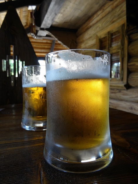 컨트리 펍의 오래된 나무 테이블에 있는 두 개의 맥주 잔