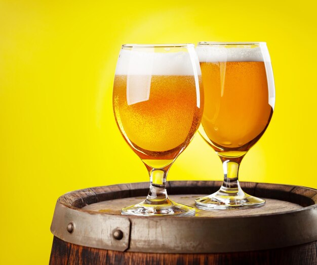 Two beer glasses on wooden barrel