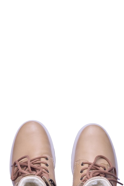 Two beige winter boots are socks up on a white background under clipping. There is a lot of space above them for advertising and inscriptions