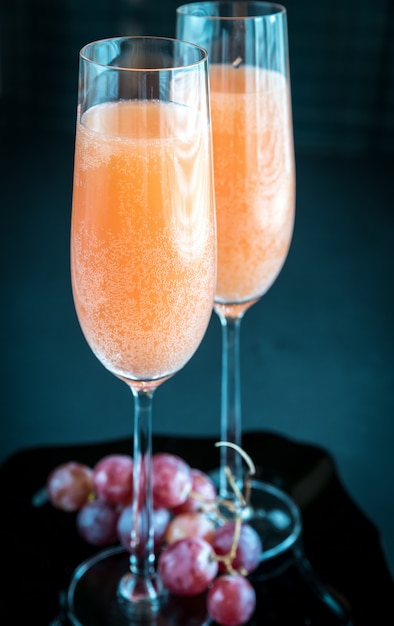 Two bellini cocktails with bunch of grapes