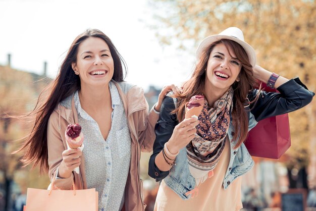 Two best friends having ice cream together outdoors