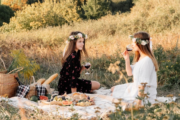 Two best friends on picnic in the field laying on the laid smiling