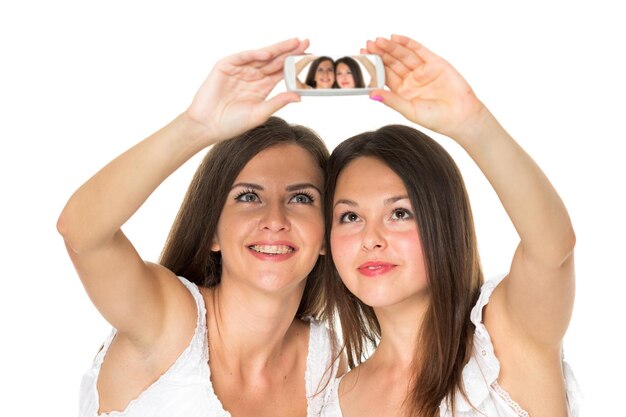 Two best friends teenage girls together having fun posing emotional on white background besties happy smiling making selfie lifestyle people concept