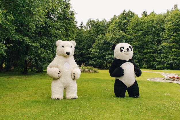 Two big teddy bears in the park in the summer