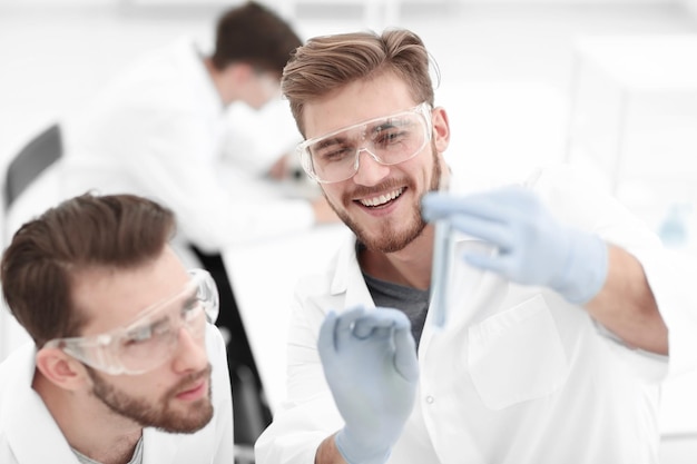 Two biologist examining liquid in a test tube