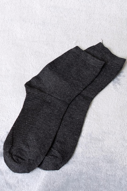 Two black socks on a gray background