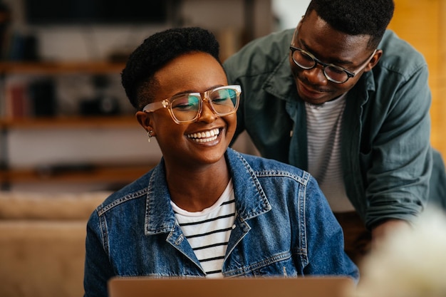 Two black workers in the home office using technology