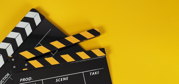 Due batacchi neri e gialli o film slate.it utilizzati nella produzione video, film, industria cinematografica su sfondo giallo.