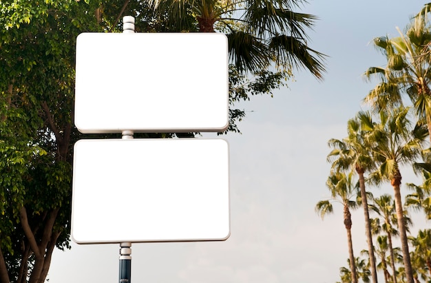 two blank advertising signs with trees and blue sky in the background