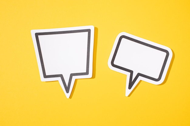 Photo two blank speech bubble isolated on yellow background mock up template