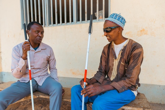 Фото Два слепых человека, сидящих на скамейке, говорят о дружбе людей, страдающих от слепоты.