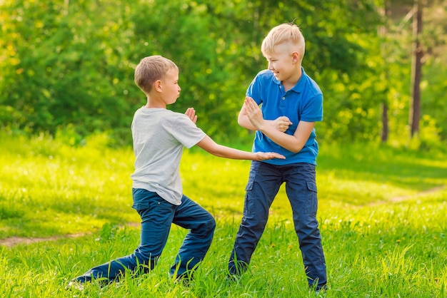 Two blond boys fighting in the park