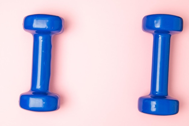Two blue of dumbbells Isolated on pink background