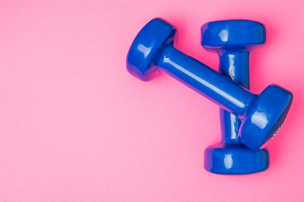 Two blue of dumbbells Isolated on pink background