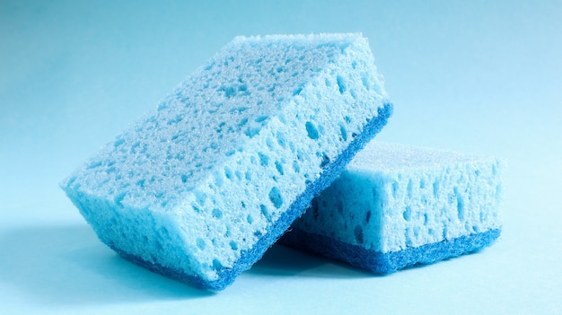 Two blue sponges used for washing and erasing dirt used by housewives in everyday life. They are made of porous material such as foam. Detergent retention, which allows you to spend it economically.