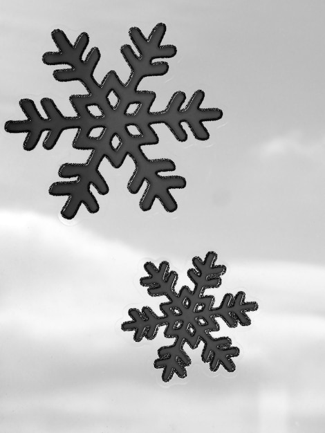 Photo two bnw geometrical snowflakes against a grey cloudly sky full length stickers on glass