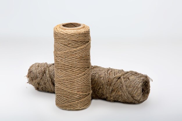 Two bobbins of decorative thread on a white background