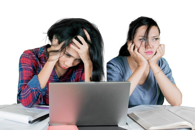 Two bored female student studying on studio