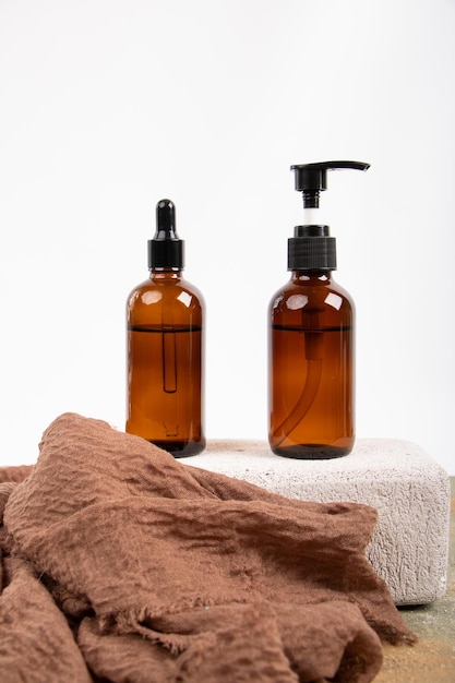 two bottles of cosmetic are on a towel and one is black