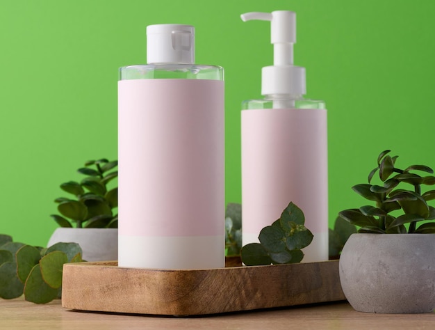 Two bottles for cosmetics with a pink paper label on a green background Bottle for tonic gel