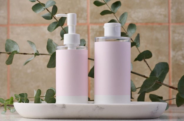 Two bottles for cosmetics with a pink paper label on a white background Bottle for tonic gel