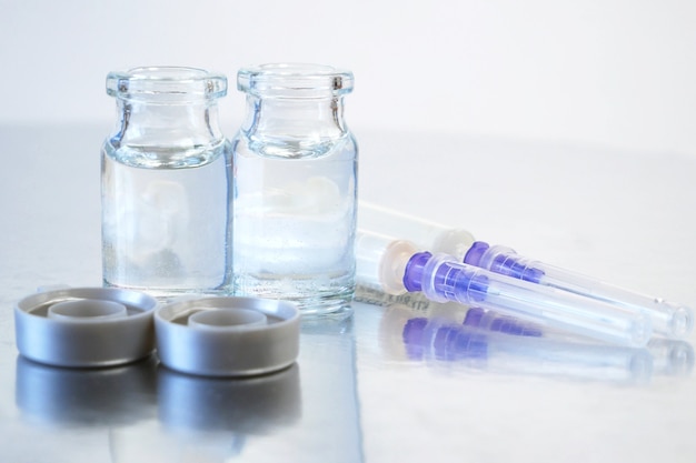 Two bottles of covid-19 coronavirus vaccine, production medicine vaccine, closeup