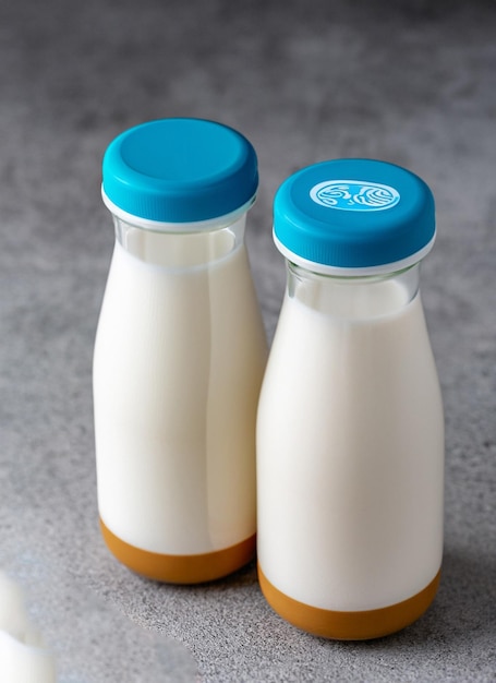 Two bottles of milk with a blue lid and the top of the bottle has a blue lid.