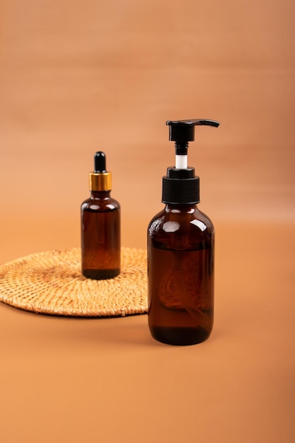 two bottles of soap are on a mat with a brown background