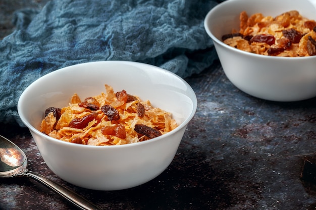 Two bowls of cornflakes on a dark table