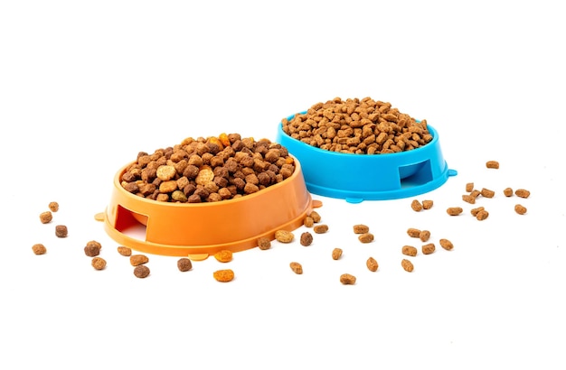 흰색 배경에 고양이와 개를 위한 마른 음식이 담긴 두 개의 그릇.