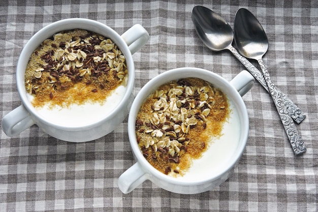 Two bowls with white yogurt, bran and seeds. Healthy breakfast. Diet food.