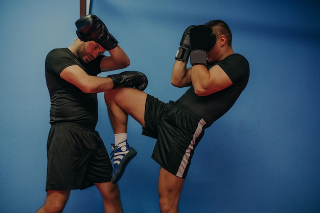 Due uomini di boxe che si esercitano insieme al centro benessere