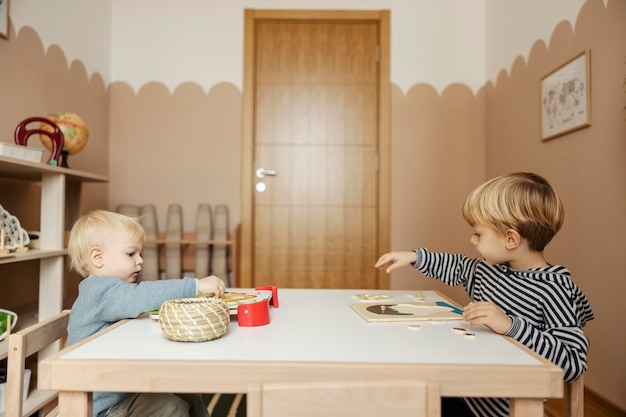 Two boys are playing in kindergarten with educational toys in playroom