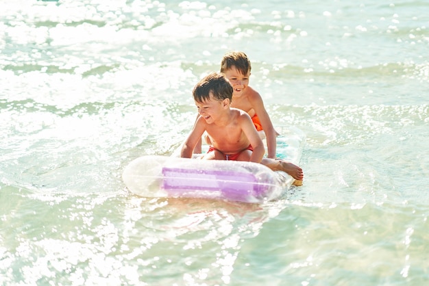 Два мальчика или брата на матрасе на Красном море