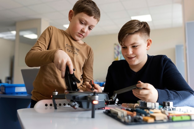 Two boys building a drone using electronic components