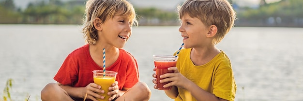 Two boys drink healthy smoothies against the backdrop of palm trees mango and watermelon smoothies