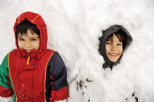 二人の男の子が雪の中に寝ている